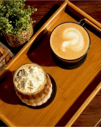 Latte and iced coffee on a wooden tray